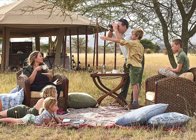 Family watching wildebeest calving season in Serengeti
